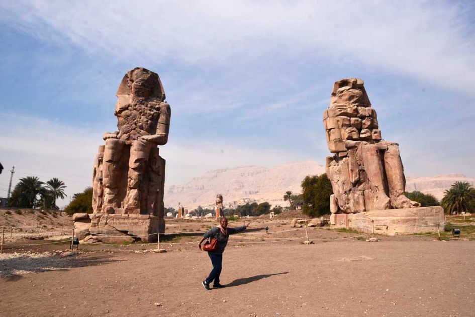 colossus of Memnon statue. How to visit amazing luxor the right way blog post. Woman in gray sweather posing