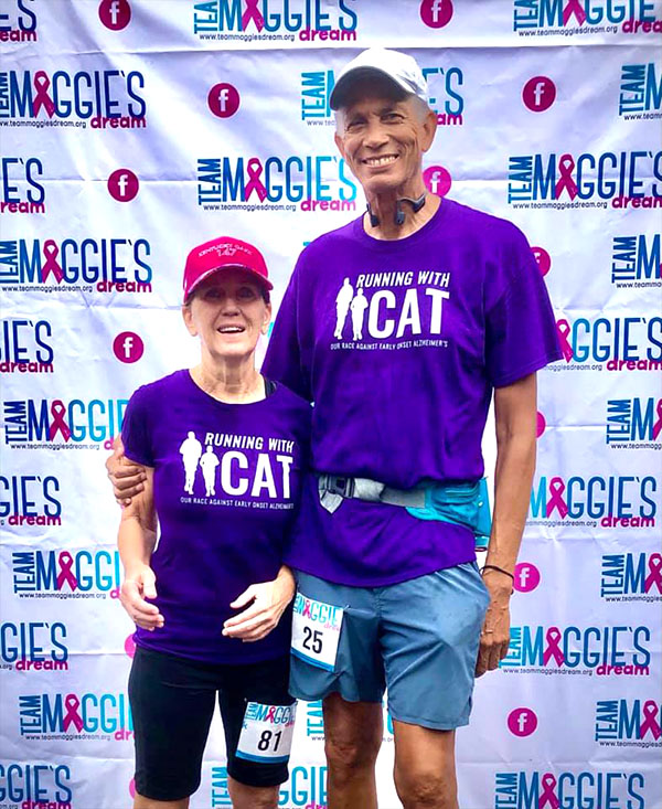 love on the run. pic of couple in front of team maggies banner with purple tee shirts
