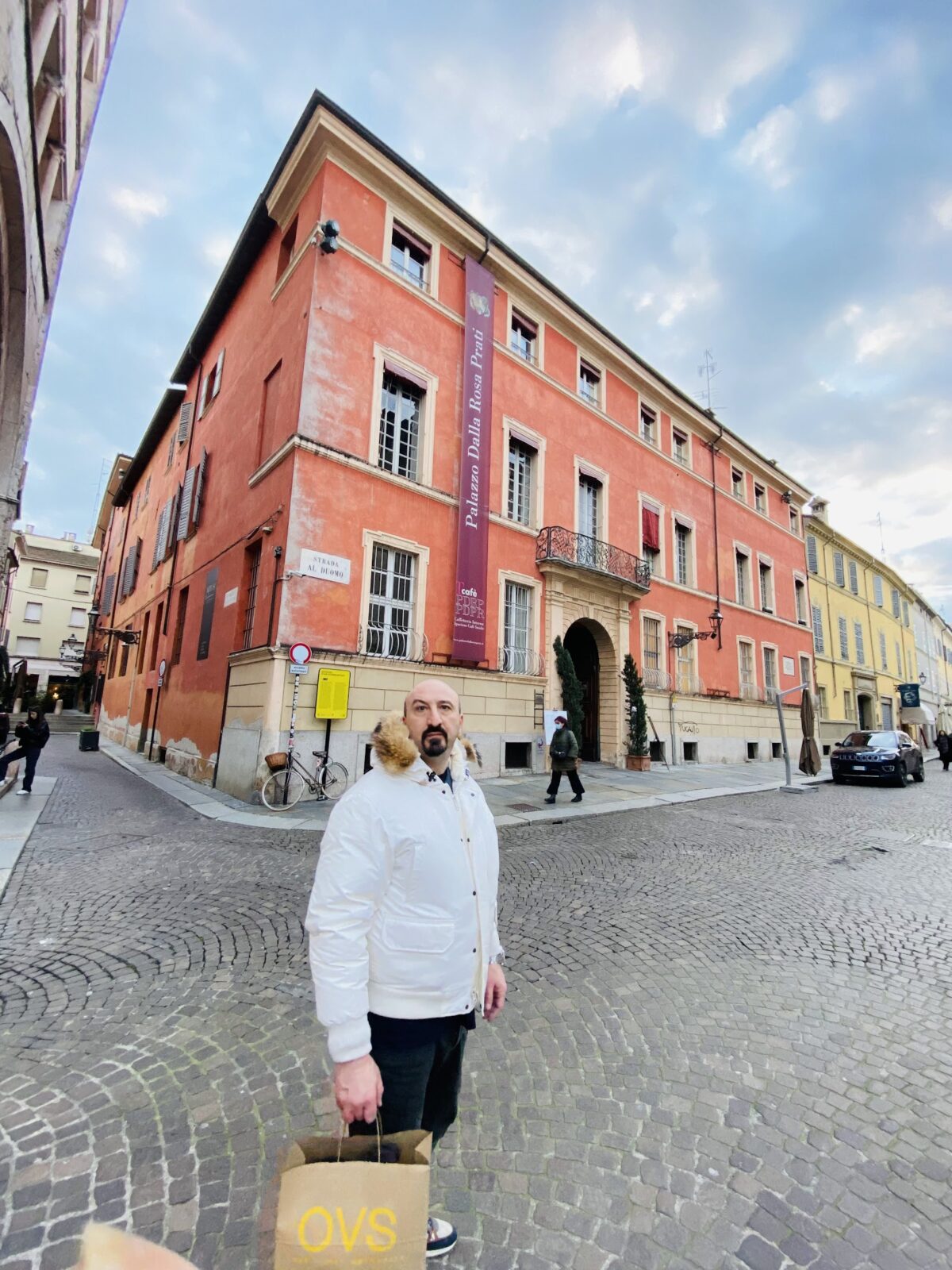 Fede in front of the dalla pratti hotel in parma in white jacket and jeans.